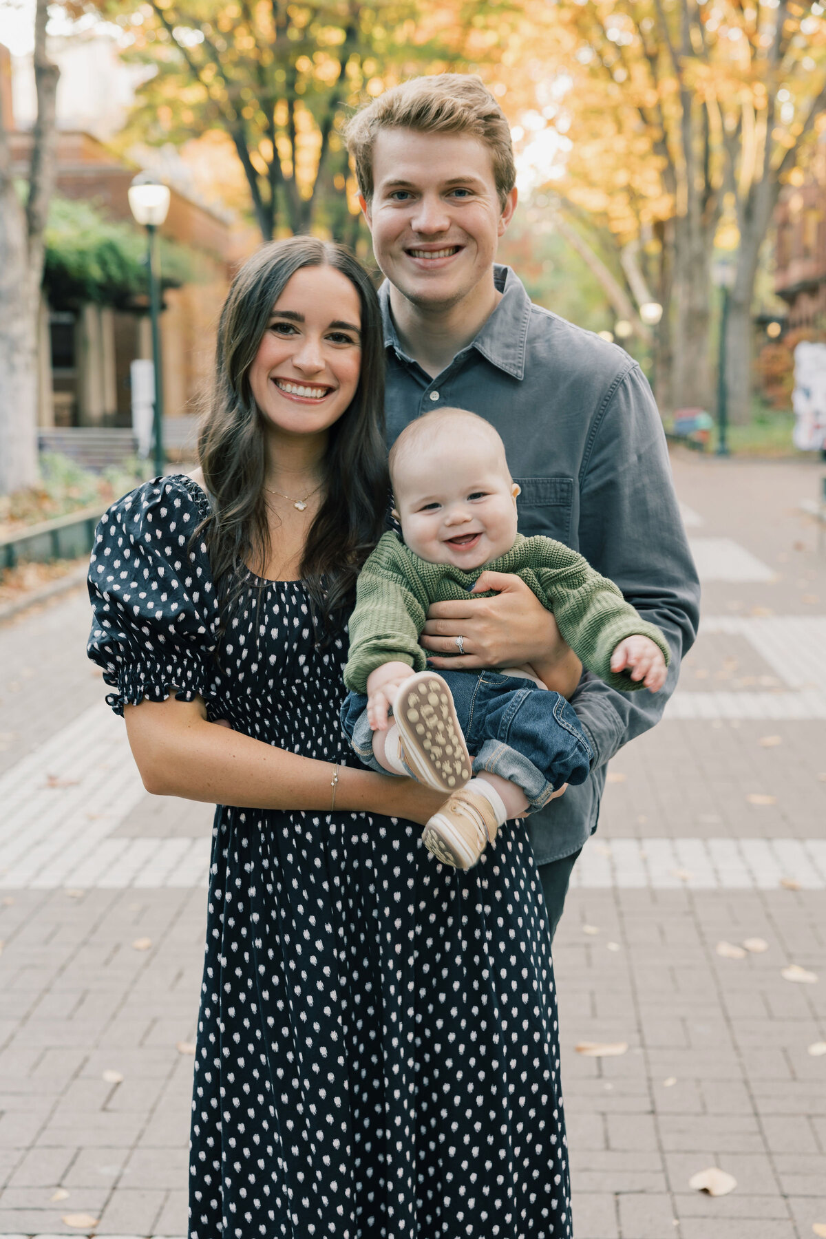 Hans Pande outdoors with his wife and child on a fall walk